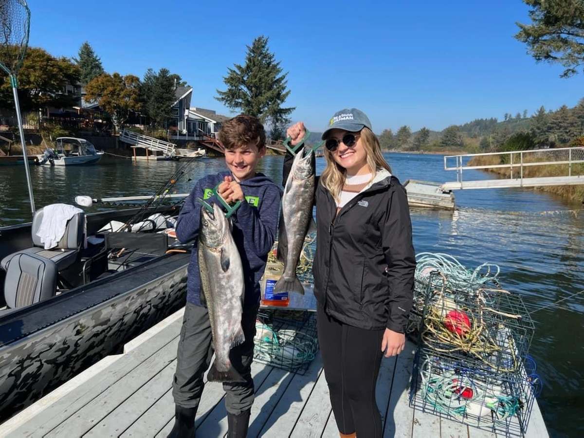Two anglers with a Siletz River salmon and crab pots on the dock