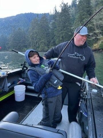 Young angler fighting a fish alongside his guide on the Siletz River