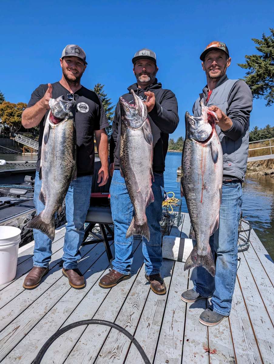 Three anglers on the dock with a limit of Oregon salmon